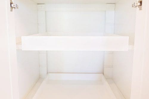 A white refrigerator with two shelves in it.