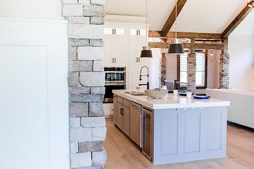 A kitchen with stone walls and an island.