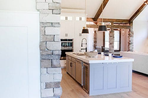 A kitchen with stone walls and an island.